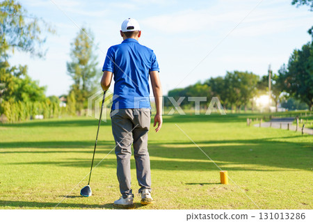 Asian male amateur golfer is enjoy playing golf at golf course in morning, he is showing his beautiful swing during tee off. Man playing golf. Asian male amateur golfer is enjoy playing golf at golf course in morning, he is showing his beautiful swing during tee off. Man playing golf. 131013286