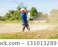 Asian male amateur golfer is enjoy playing golf at golf course in morning, he is showing his beautiful swing during tee off. Man playing golf. 131013289