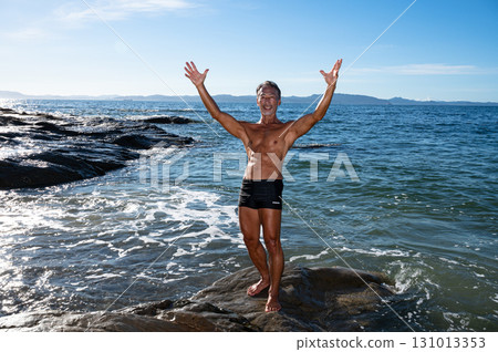Portrait of a senior man with a well-trained body at the seaside Portrait of a senior man with a well-trained body at the seaside 131013353
