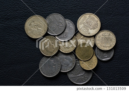 Old Spanish peso coins on black leather 131013509