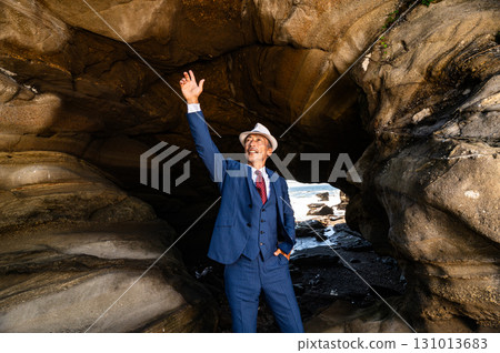 A man in a suit standing in a cave A man in a suit standing in a cave 131013683
