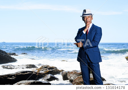 Portrait of a dandy middle-aged man in a suit at the sea 131014178