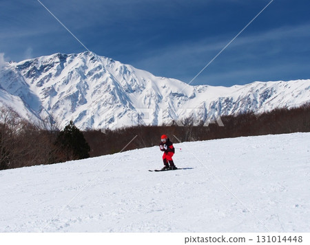 Hakuba Iwatake Snowfield - Skiers skiing down Sunny Valley with Mount Yari in the background 131014448