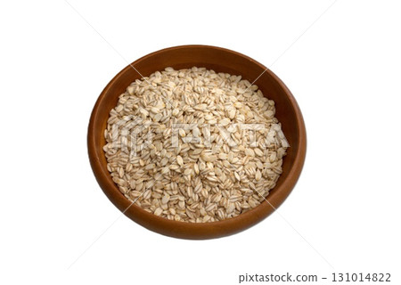 Rolled barley served in a wooden bowl 131014822