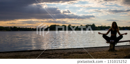 Experience the calming and beautiful practice of serene meditation at sunset by the water 131015252