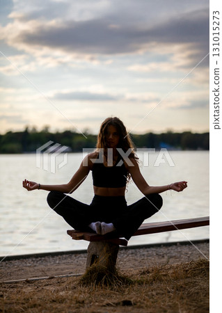 Engaging in a Peaceful Yoga Practice by the Water while Enjoying the Beautiful Sunset Engaging in a Peaceful Yoga Practice by the Water while Enjoying the Beautiful Sunset 131015273