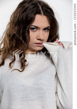 A Young Woman Dressed in a Sweater Posed Near a Textured Background, Capturing Beauty 131015343