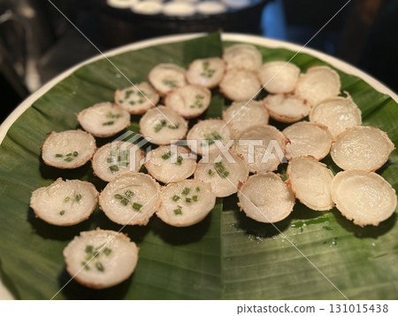 Small appetizers garnished with chives served on a green banana leaf Small appetizers garnished with chives served on a green banana leaf 131015438