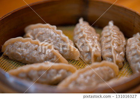 Steamed Korean dumplings Mandu with meat and vegetables in a bamboo steamer 131016327