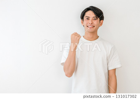 A young Asian man in a T-shirt pumping his fist (motivated, expectant, happy, successful, energetic, pleased, delighted) A young Asian man in a T-shirt pumping his fist (motivated, expectant, happy, successful, energetic, pleased, delighted) 131017302