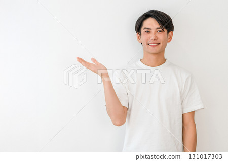 A young Asian man in a T-shirt giving a tour (introduction, guide, recommendation, guidance) A young Asian man in a T-shirt giving a tour (introduction, guide, recommendation, guidance) 131017303