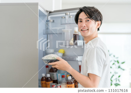 Young Asian man taking out ingredients from the refrigerator 131017616