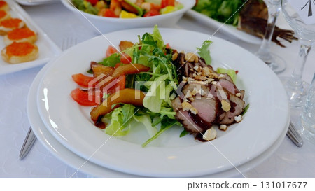 Seared duck breast resting on crisp arugula, accompanied by caramelized pears, ripe tomatoes, and glossy balsamic reduction, highlighting gourmet flavor profiles 131017677