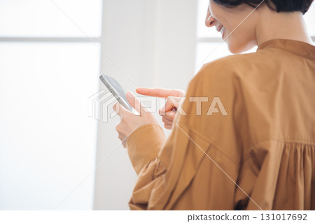 一位 40 多歲的女性正在操作智慧型手機 一位 40 多歲的女性正在操作智慧型手機 131017692