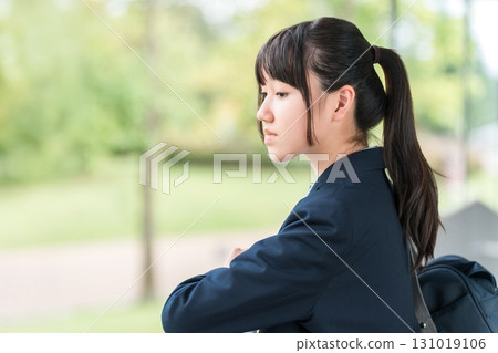 一名高中女生在上學、上學或放學途中低頭、心情低落的側面照（悲傷、擔心、焦慮） 131019106