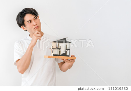 A young Asian man worried about his house model (my own home, detached house) 131019280