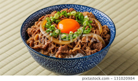 Gyudon with Raw Egg Yolk, Onion, and Green Onion in Blue Ceramic Bowl 131020984