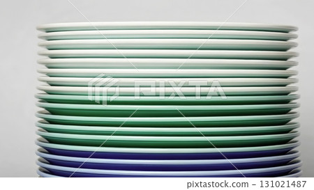 Stacked plates in varying shades of green and blue show creative design in a modern kitchen setting 131021487