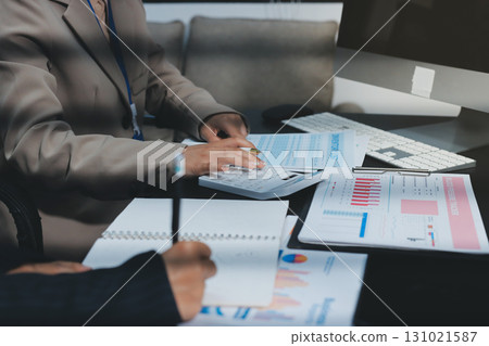 Close up high angle Asian businesswoman working with her coworker in meeting room Close up high angle Asian businesswoman working with her coworker in meeting room 131021587