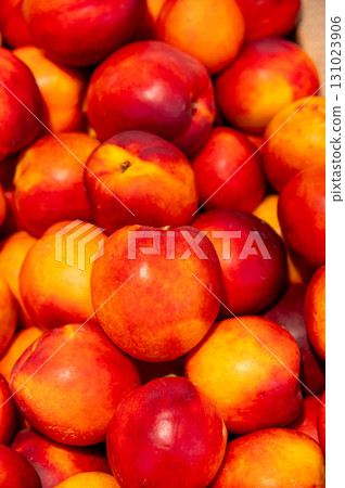Brightly colored nectarines at the market. A vertical photo of the juicy, fresh fruit Brightly colored nectarines at the market. A vertical photo of the juicy, fresh fruit 131023906