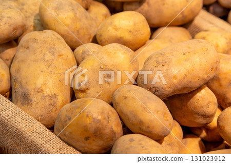 Selected potatoes in a basket at the market. Close-up of large fresh potatoes, the new harvest on the counter Selected potatoes in a basket at the market. Close-up of large fresh potatoes, the new harvest on the counter 131023912