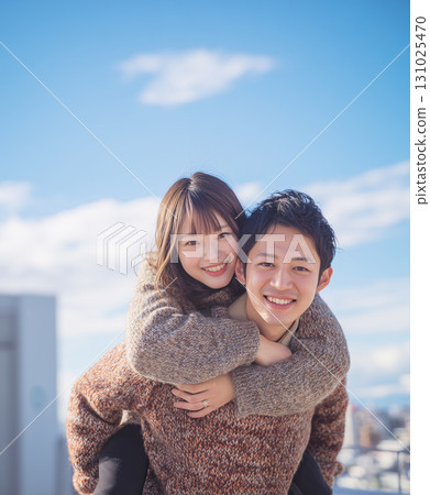 Couple cuddling under blue sky 131025470