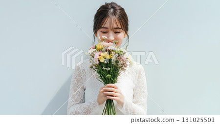 Portrait of a young woman standing elegantly with a bouquet of flowers 131025501