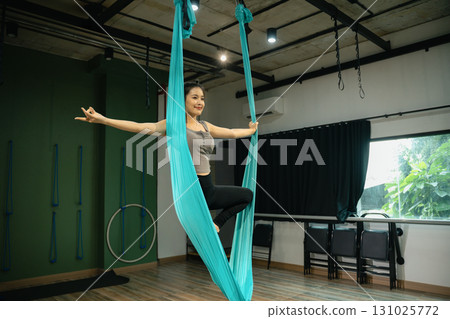 Young woman slim body fitness girl practicing fly yoga in the gym 131025772