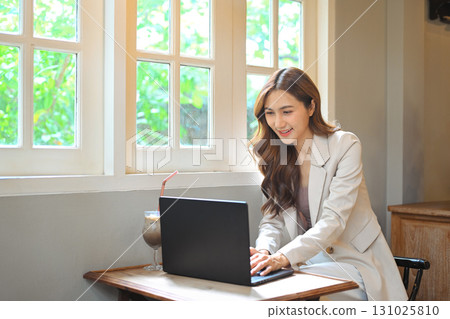 Digital nomad concept, Asian woman working with her laptop in cafe Digital nomad concept, Asian woman working with her laptop in cafe 131025810