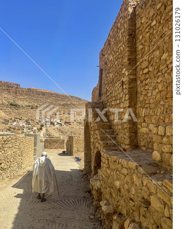 Walking through the historic streets of Toudjane in Tunisia under a clear blue sky 131026179