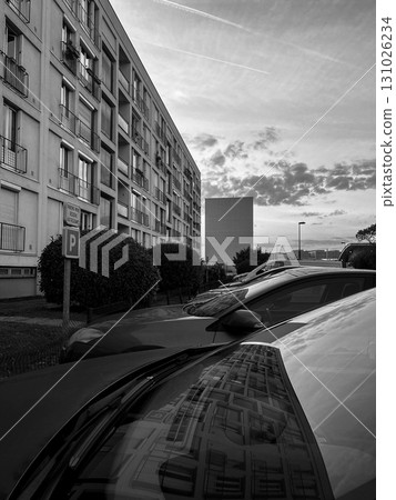 Reflections of buildings on a parked car during sunset in an urban area 131026234