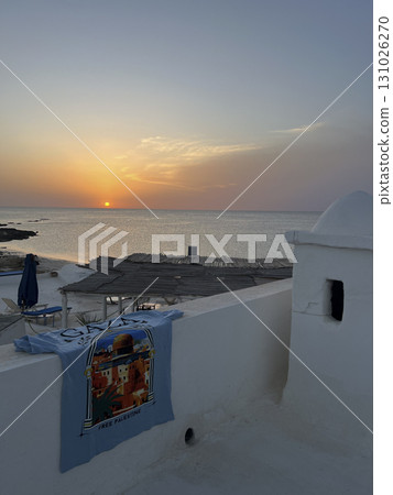 Sunset view from a white house in Djerba, Tunisia with a free Palestine t-shirt hanging on the wall 131026270