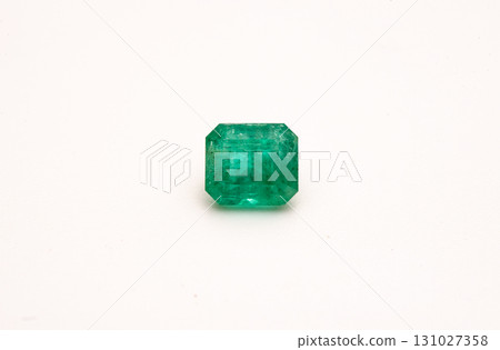 A green gemstone sits on a white background 131027358