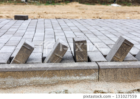 Newly Laid Paving Stones on a Developing Pedestrian Pathway in a Park, Showcasing Modern Urban Design and Natural Surroundings Newly Laid Paving Stones on a Developing Pedestrian Pathway in a Park, Showcasing Modern Urban Design and Natural Surroundings 131027559