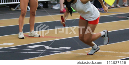 Runner Prepares for Baton Exchange During a Relay Race Runner Prepares for Baton Exchange During a Relay Race 131027836