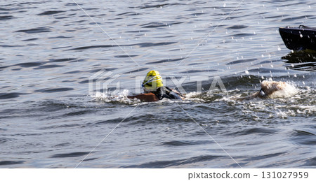 Competitive Swimmer Gliding Through Calm Water With Bright Yellow Cap 131027959