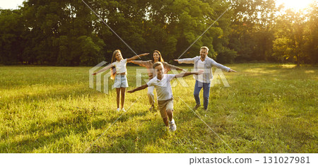 Happy family with two kids running and having fun in summer park at sunset. Happy family with two kids running and having fun in summer park at sunset. 131027981