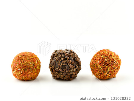 Three chocolate covered balls with different toppings 131028222