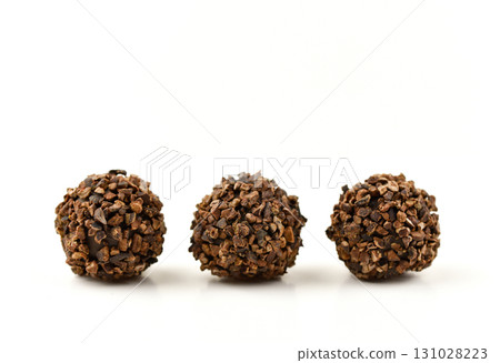 Three brown balls of chocolate with a grainy texture 131028223