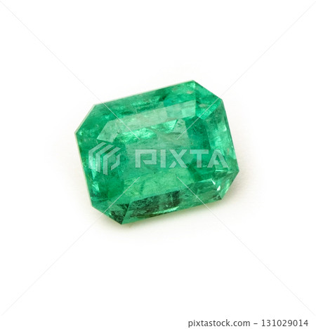 A green gemstone is sitting on a white background A green gemstone is sitting on a white background 131029014