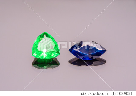 Two gemstones, one green and one blue, are displayed on a table Two gemstones, one green and one blue, are displayed on a table 131029031