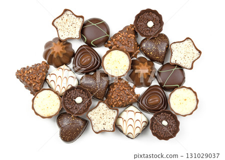 A large assortment of chocolate truffles are displayed on a white background 131029037