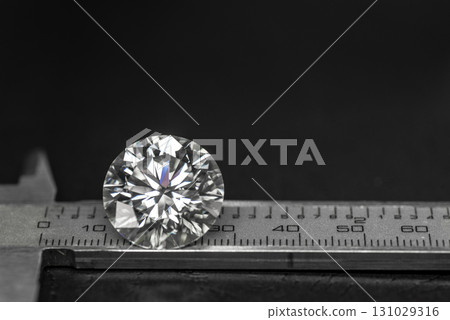 A diamond is on a ruler, and the ruler is black 131029316