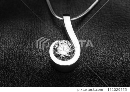 A silver pendant with a large diamond in the center 131029353