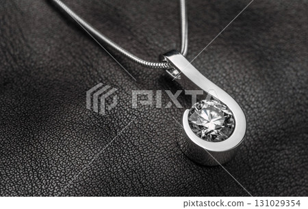 A silver pendant with a large diamond in the center 131029354