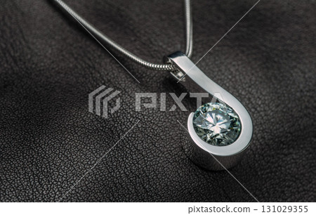 A silver pendant with a blue stone in the center A silver pendant with a blue stone in the center 131029355