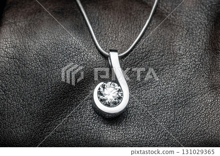 A silver pendant with a large diamond in the center 131029365
