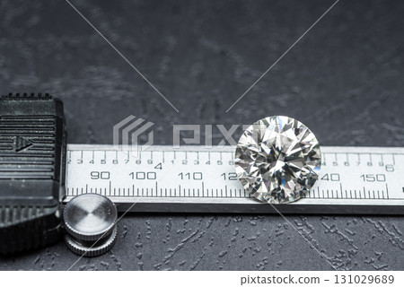 A diamond is on a ruler and the ruler is black 131029689
