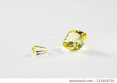 Two yellow gemstones are on a white background 131029718