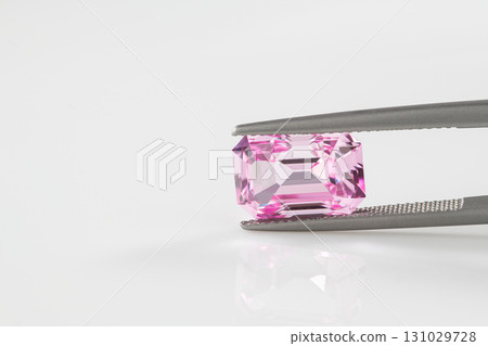 A pink gemstone is being held in a metal clamp A pink gemstone is being held in a metal clamp 131029728